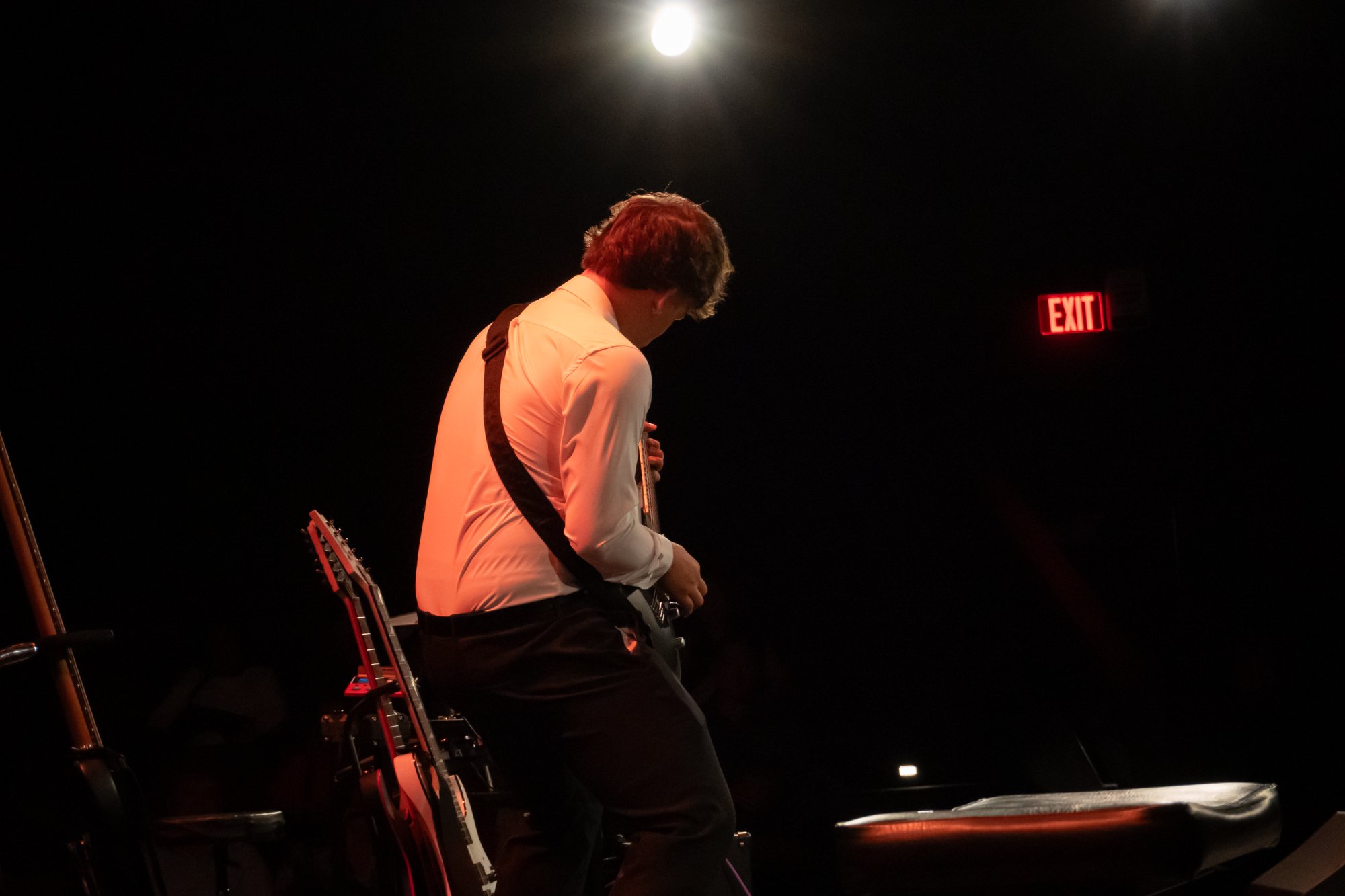 Guitarist under spotlight from behind